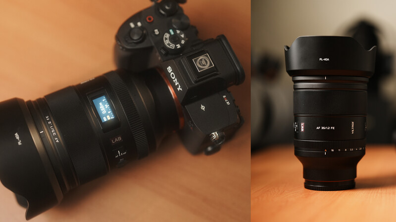 Sony camera with attached lens and separate telephoto lens displayed on warm orange surface