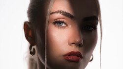 Portrait of a woman with dramatic side lighting creating a split-face effect with deep shadows.