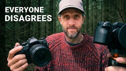 Photographer holding two mirrorless cameras against forest backdrop with text overlay reading 'EVERYONE DISAGREES'