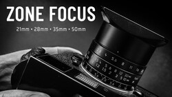 Manual focus lens with zone focus markings mounted on vintage camera body against dark background